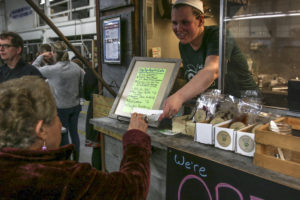 Ugly Apple food cart owner Laurel hands samples to a customer at May 2019 Sneak Peek Event