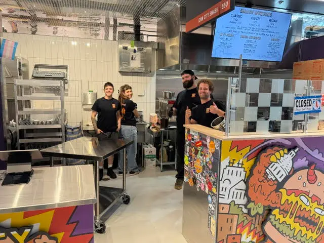 Group of staff members gathered at a colorful workshop counter