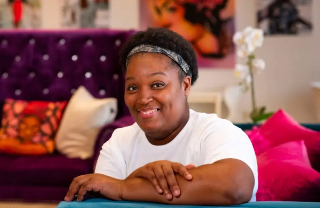 Portrait of a smiling merchant sitting on a purple couch