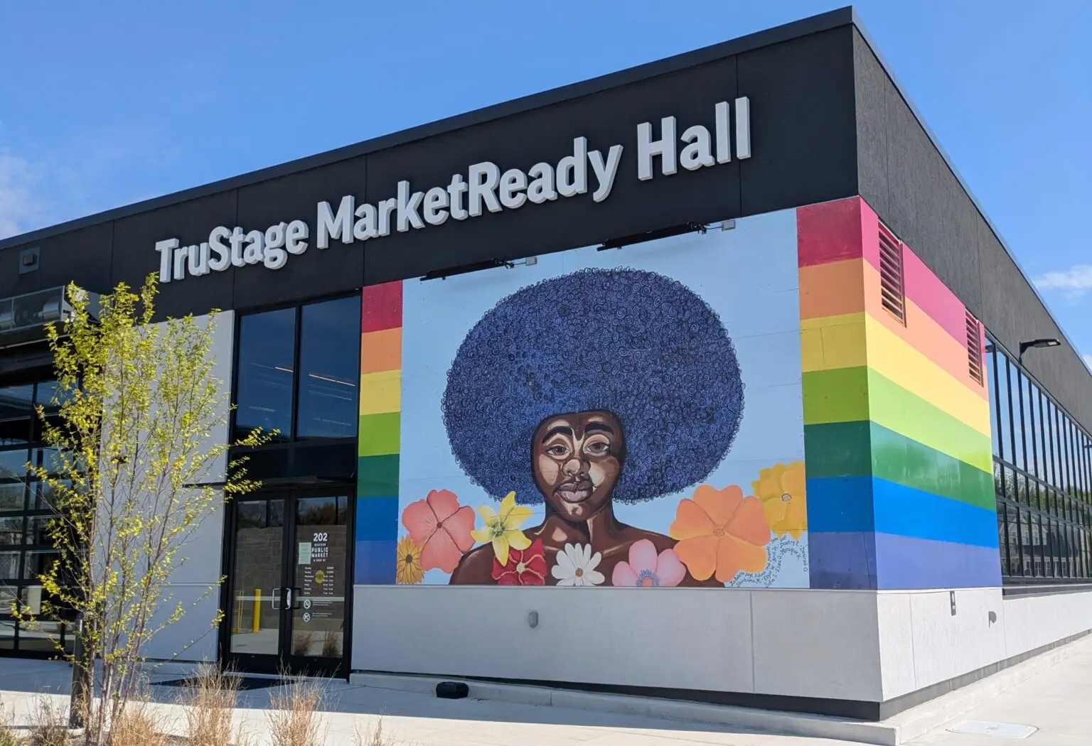 Exterior of TruStage MarketReady Hall featuring a rainbow portrait mural