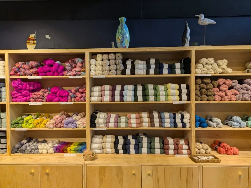 Shelves of colorful yarn skeins displayed in a merchant shop at Madison Public Market
